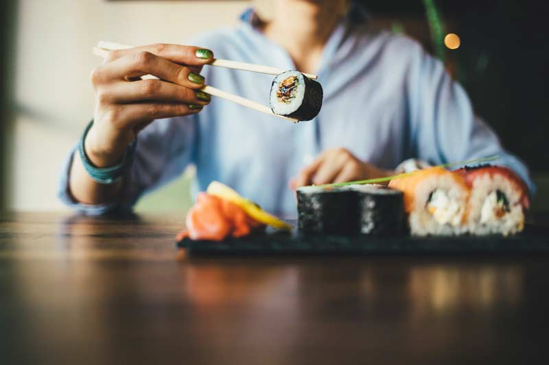 Kvinna äter sushi.